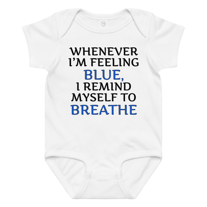 "Whenever I'm feeling blue, I remind myself to breathe" printed on a white baby jersey bodysuit laying on a flat surface amongst other clothes