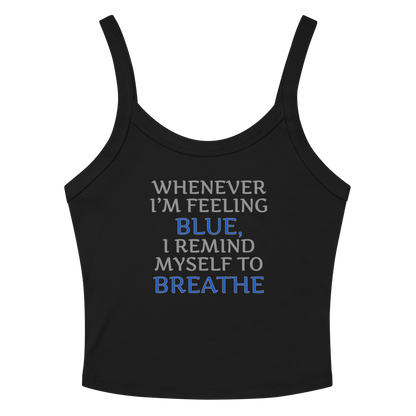 "Whenever I'm feeling blue, I remind myself to breathe" printed on a solid black blend women's micro-rib tanktop laying on a flat surface amongst sunglasses and shorts