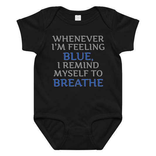 "Whenever I'm feeling blue, I remind myself to breathe" printed on a black baby jersey bodysuit laying on a flat surface amongst other clothes