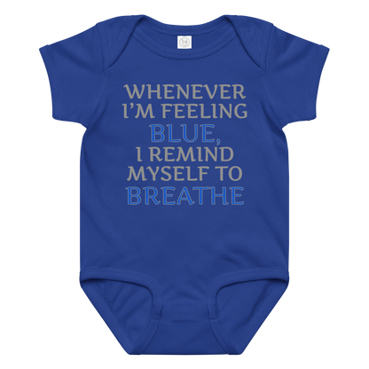 "Whenever I'm feeling blue, I remind myself to breathe" printed on a royal baby jersey bodysuit laying on a flat surface amongst other clothes