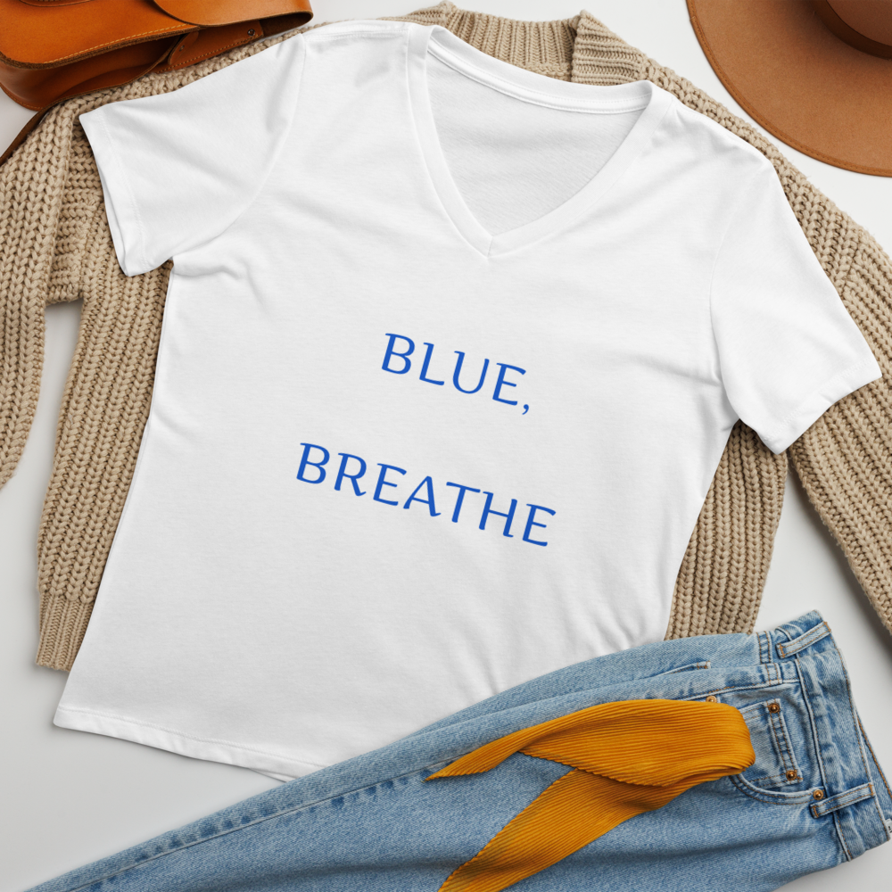 "Whenever I'm feeling blue, I remind myself to breathe" printed on a solid white blend women's relaxed v-neck t-shirt laying on a flat surface amongst other clothes