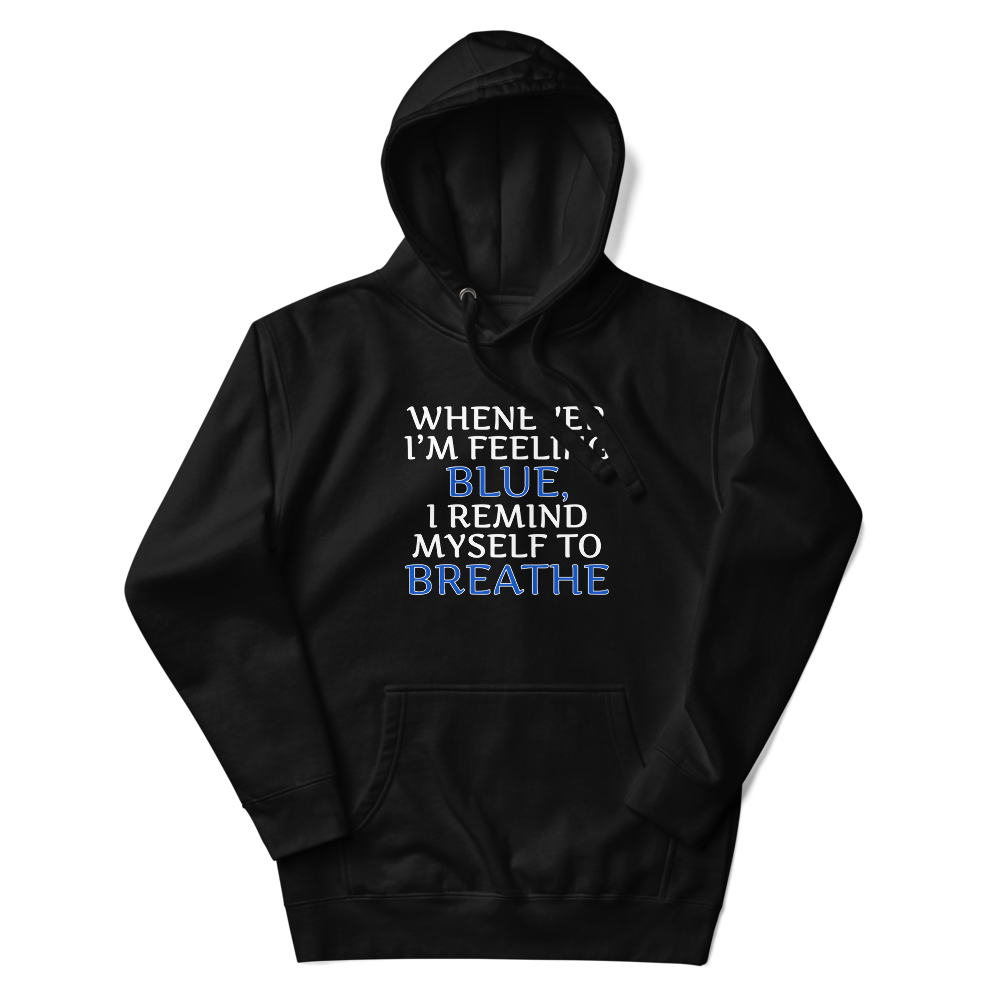 "Whenever I'm feeling blue, I remind myself to breathe" printed on a black unisex hoodie laying on a flat surface with the hood up