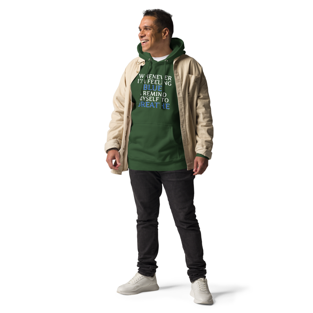"Whenever I'm feeling blue, I remind myself to breathe" printed on a forest green unisex hoodie worn by a male with a jacket on top