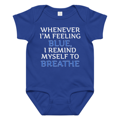 "Whenever I'm feeling blue, I remind myself to breathe" printed on a royal baby jersey bodysuit laying on a flat surface amongst other clothes
