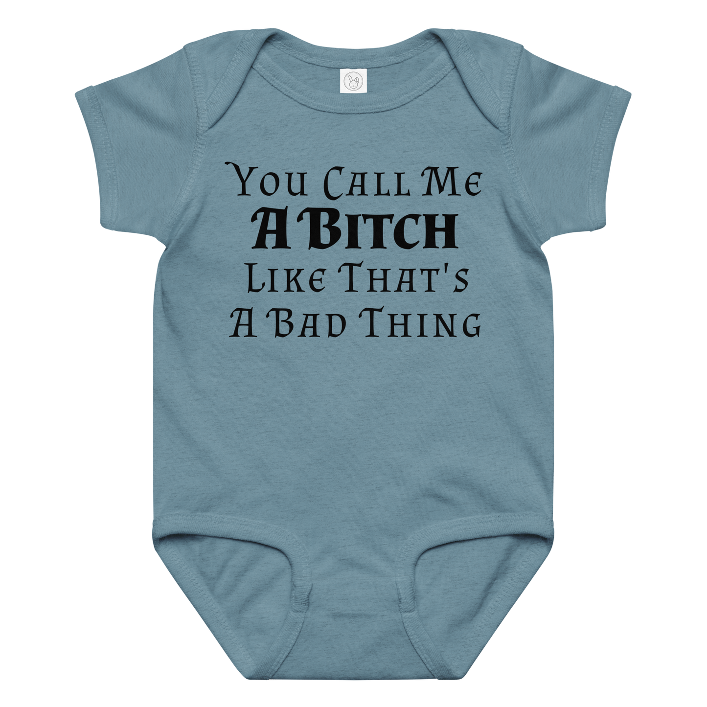 "You Call Me A Bitch Like That's A Bad Thing" printed on a vintage indigo baby jersey bodysuit laying on a flat surface amongst other clothes