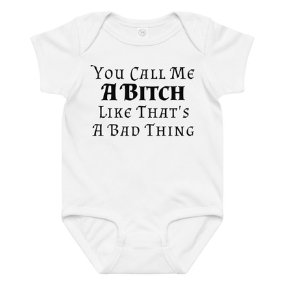 "You Call Me A Bitch Like That's A Bad Thing" printed on a white baby jersey bodysuit laying on a flat surface amongst other clothes