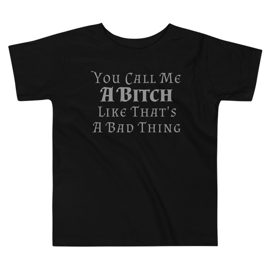 "You Call Me A Bitch Like That's A Bad Thing" printed on a black toddler short sleeve tee laying on a flat surface