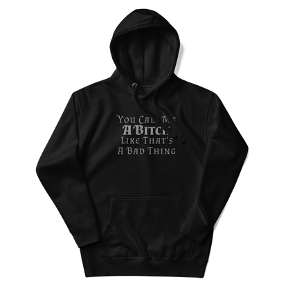 "You Call Me A Bitch Like That's A Bad Thing" printed on a black unisex hoodie laying on a flat surface with the hood up