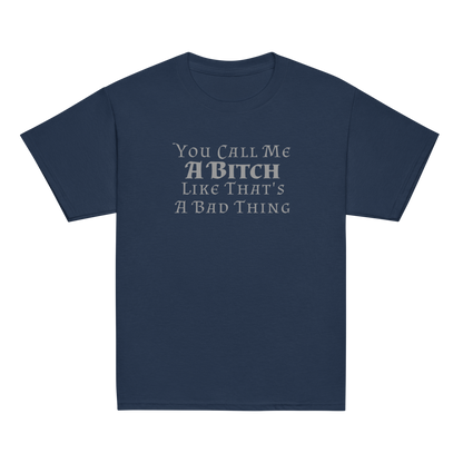 "You Call Me A Bitch Like That's A Bad Thing" printed on a navy youth classic tee laying on a flat surface