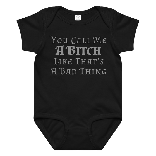 "You Call Me A Bitch Like That's A Bad Thing" printed on a black baby jersey bodysuit laying on a flat surface amongst other clothes