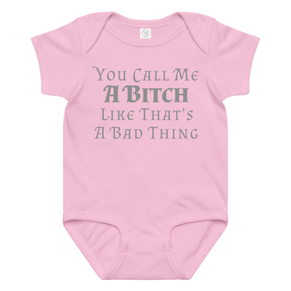 "You Call Me A Bitch Like That's A Bad Thing" printed on a pink baby jersey bodysuit laying on a flat surface amongst other clothes