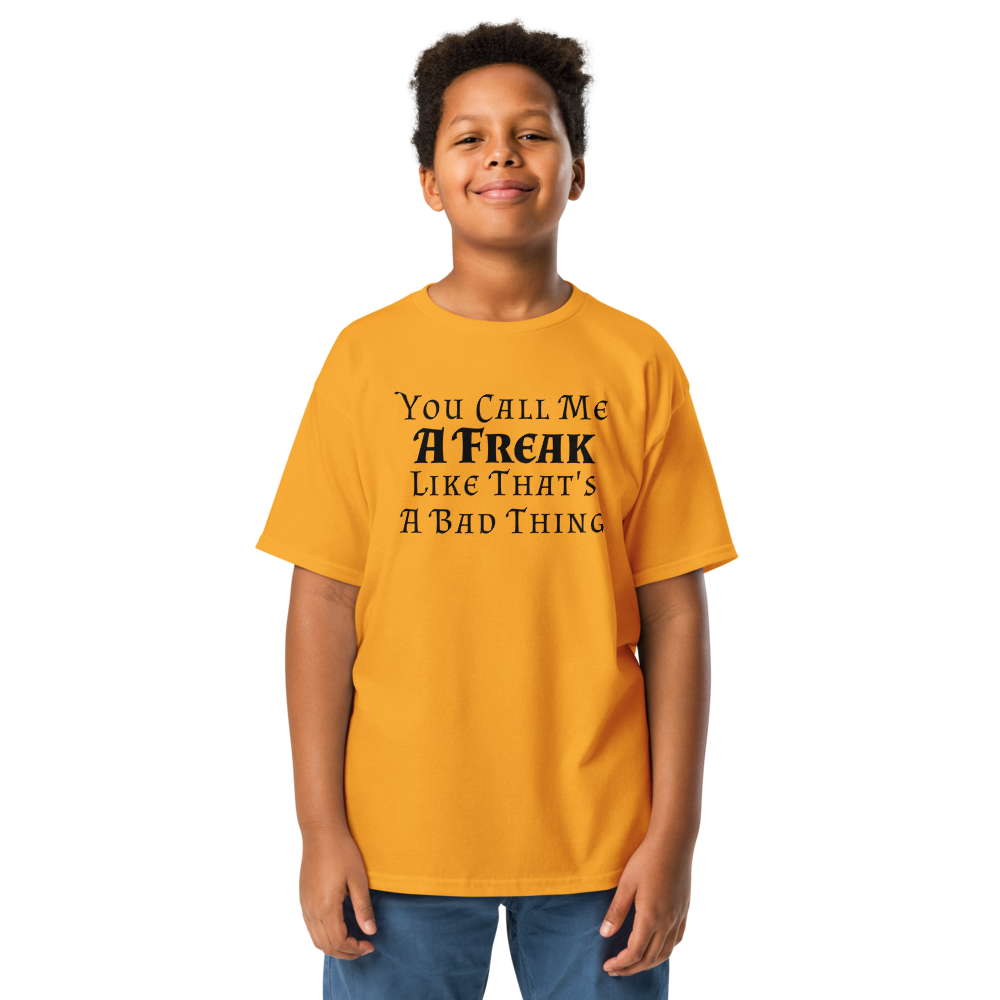"You Call Me A Freak Like That's A Bad Thing" printed on a gold youth classic tee worn by a male