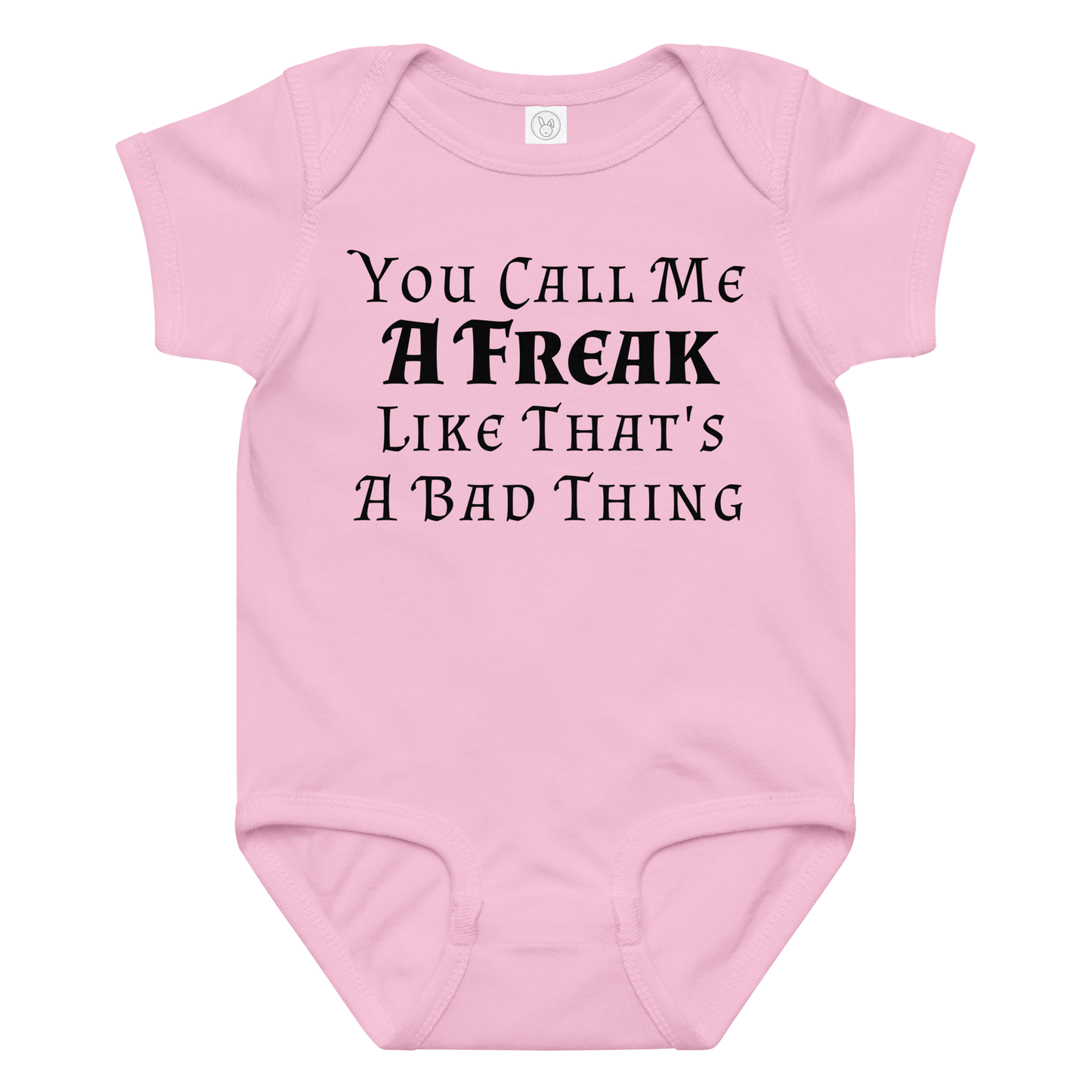 "You Call Me A Freak Like That's A Bad Thing" printed on a pink baby jersey bodysuit laying on a flat surface amongst other clothes