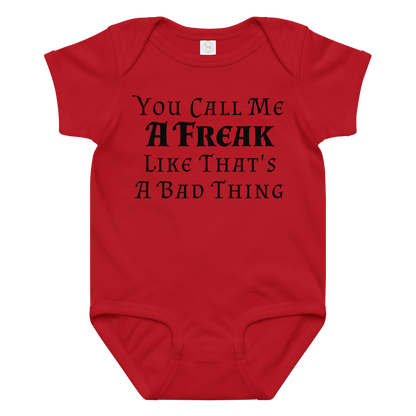 "You Call Me A Freak Like That's A Bad Thing" printed on a red baby jersey bodysuit laying on a flat surface amongst other clothes