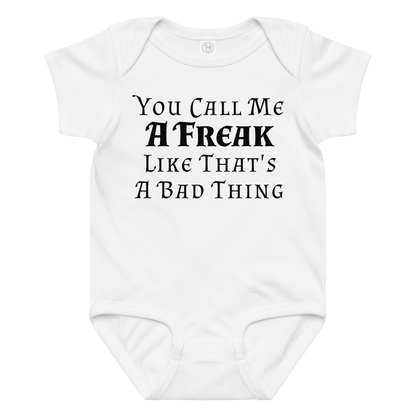 "You Call Me A Freak Like That's A Bad Thing" printed on a white baby jersey bodysuit laying on a flat surface amongst other clothes
