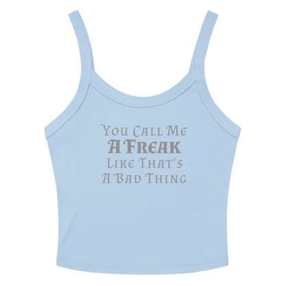 "You Call Me A Freak Like That's A Bad Thing" printed on a solid baby blue blend women's micro-rib tanktop laying on a flat surface amongst sunglasses and shorts