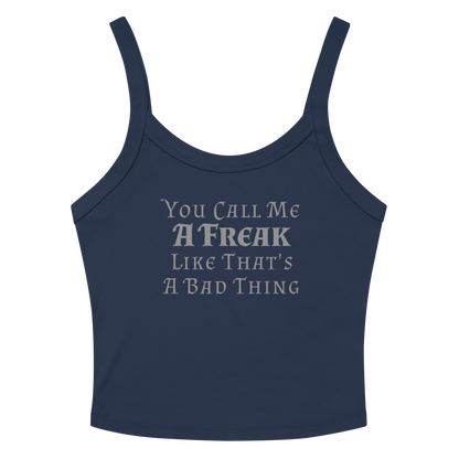 "You Call Me A Freak Like That's A Bad Thing" printed on a solid navy blend women's micro-rib tanktop laying on a flat surface amongst sunglasses and shorts