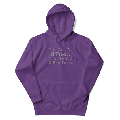 "You Call Me A Freak Like That's A Bad Thing" printed on a purple unisex hoodie laying on a flat surface with the hood up