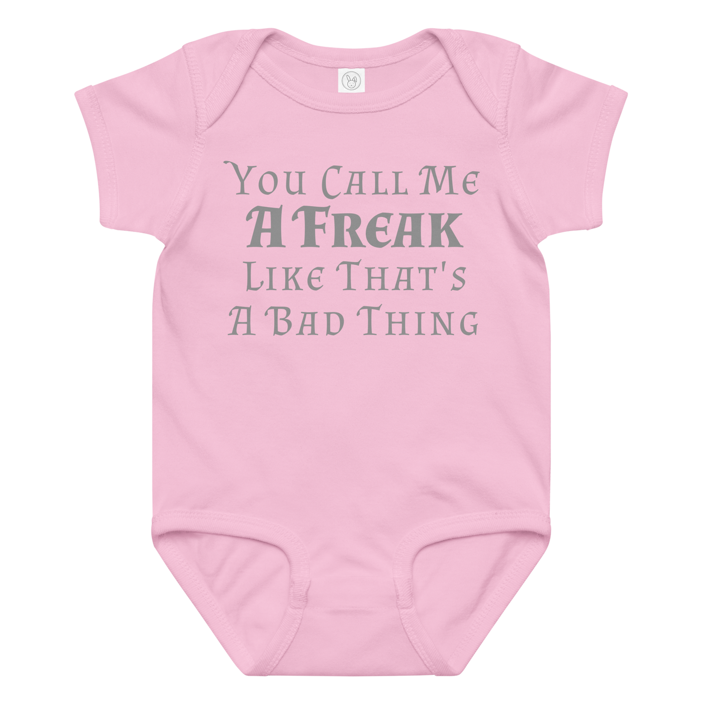 "You Call Me A Freak Like That's A Bad Thing" printed on a pink baby jersey bodysuit laying on a flat surface amongst other clothes
