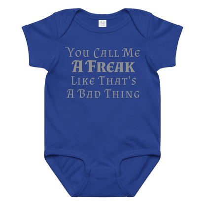 "You Call Me A Freak Like That's A Bad Thing" printed on a royal baby jersey bodysuit laying on a flat surface amongst other clothes