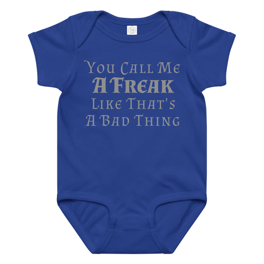 "You Call Me A Freak Like That's A Bad Thing" printed on a royal baby jersey bodysuit laying on a flat surface amongst other clothes