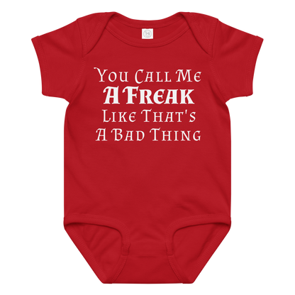 "You Call Me A Freak Like That's A Bad Thing" printed on a red baby jersey bodysuit laying on a flat surface amongst other clothes