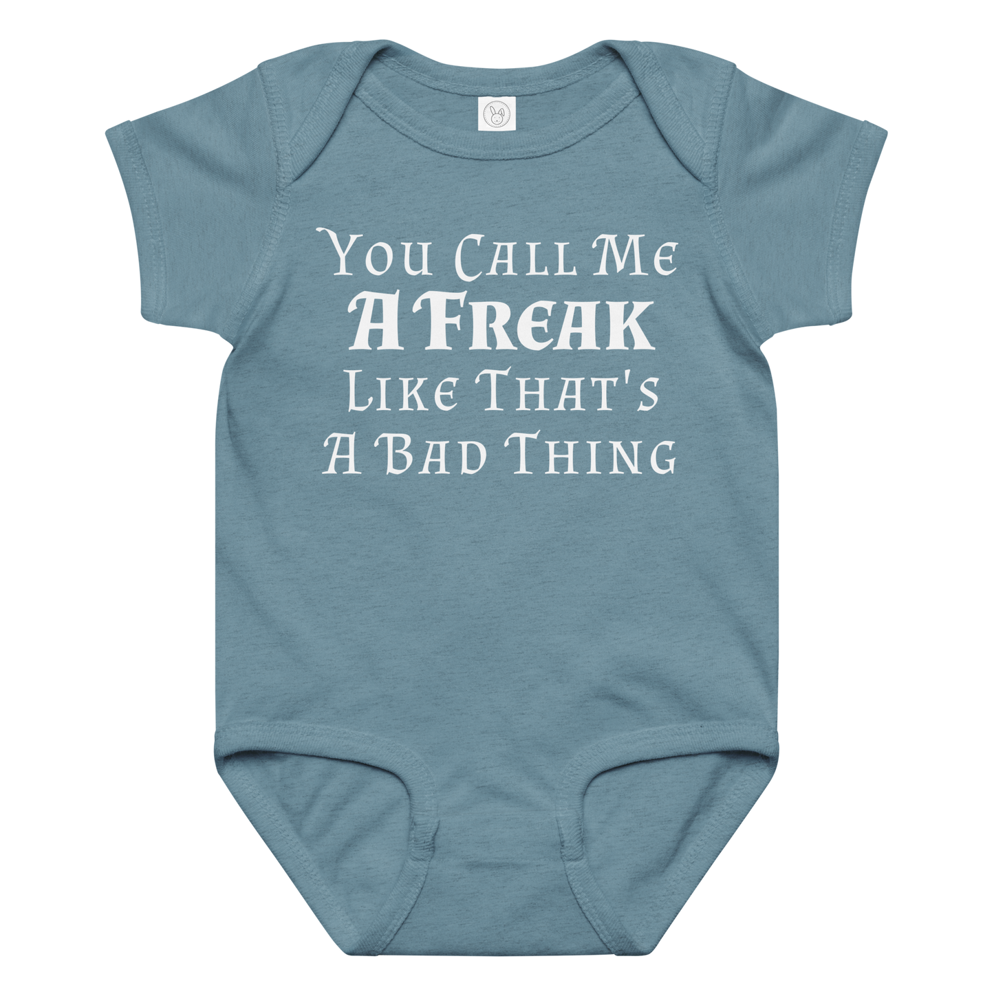 "You Call Me A Freak Like That's A Bad Thing" printed on a vintage indigo baby jersey bodysuit laying on a flat surface amongst other clothes