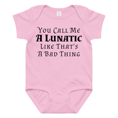 "You Call Me A Lunatic Like That's A Bad Thing" printed on a pink baby jersey bodysuit laying on a flat surface amongst other clothes