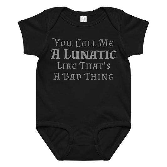 "You Call Me A Lunatic Like That's A Bad Thing" printed on a black baby jersey bodysuit laying on a flat surface amongst other clothes