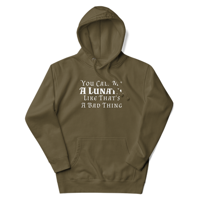 "You Call Me A Lunatic Like That's A Bad Thing" printed on a military green unisex hoodie laying on a flat surface with the hood up