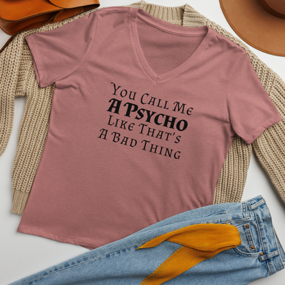 "You Call Me A Psycho Like That's A Bad Thing" printed on a heather mauve women's relaxed v-neck t-shirt laying on a flat surface amongst other clothes