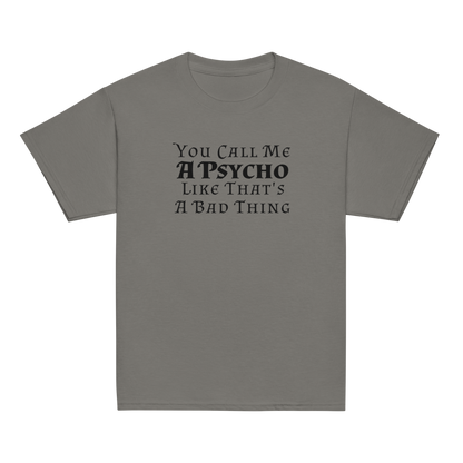 "You Call Me A Psycho Like That's A Bad Thing" printed on a charcoal youth classic tee laying on a flat surface