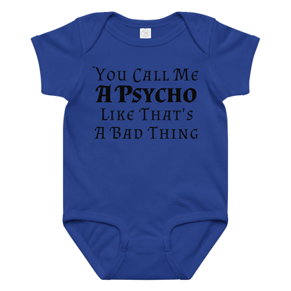 "You Call Me A Psycho Like That's A Bad Thing" printed on a royal baby jersey bodysuit laying on a flat surface amongst other clothes