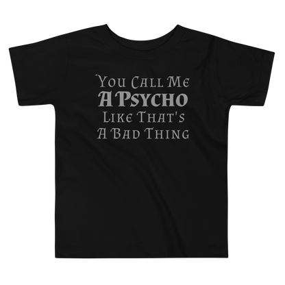 "You Call Me A Psycho Like That's A Bad Thing" printed on a black toddler short sleeve tee laying on a flat surface