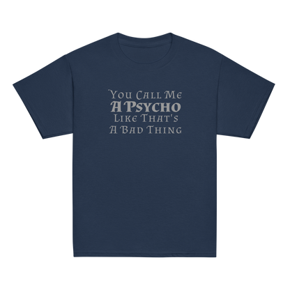 "You Call Me A Psycho Like That's A Bad Thing" printed on a navy youth classic tee laying on a flat surface