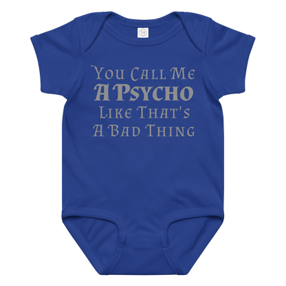 "You Call Me A Psycho Like That's A Bad Thing" printed on a royal baby jersey bodysuit laying on a flat surface amongst other clothes