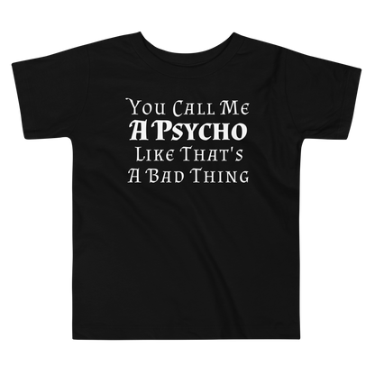 "You Call Me A Psycho Like That's A Bad Thing" printed on a black toddler short sleeve tee laying on a flat surface