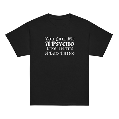 "You Call Me A Psycho Like That's A Bad Thing" printed on a black youth classic tee laying on a flat surface