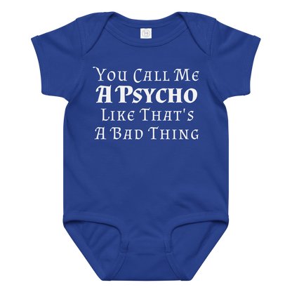 "You Call Me A Psycho Like That's A Bad Thing" printed on a royal baby jersey bodysuit laying on a flat surface amongst other clothes