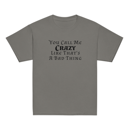 "You Call Me Crazy Like That's A Bad Thing" printed on a charcoal youth classic tee laying on a flat surface