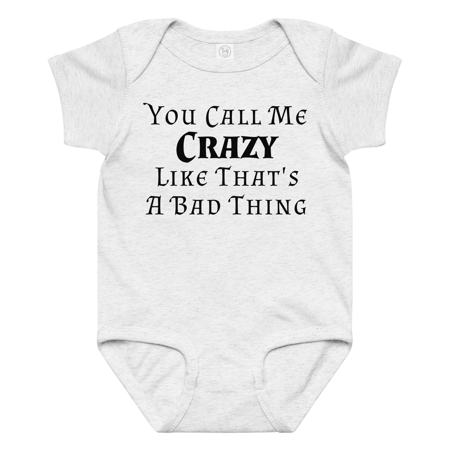 "You Call Me Crazy Like That's A Bad Thing" printed on a ash baby jersey bodysuit laying on a flat surface amongst other clothes