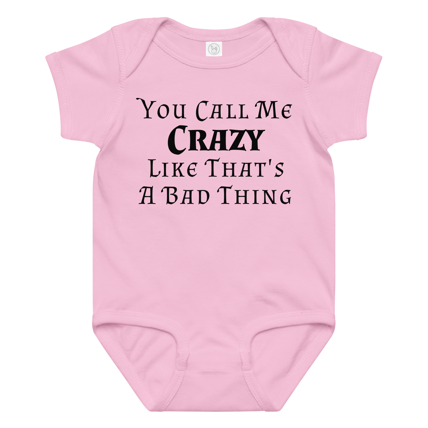 "You Call Me Crazy Like That's A Bad Thing" printed on a pink baby jersey bodysuit laying on a flat surface amongst other clothes