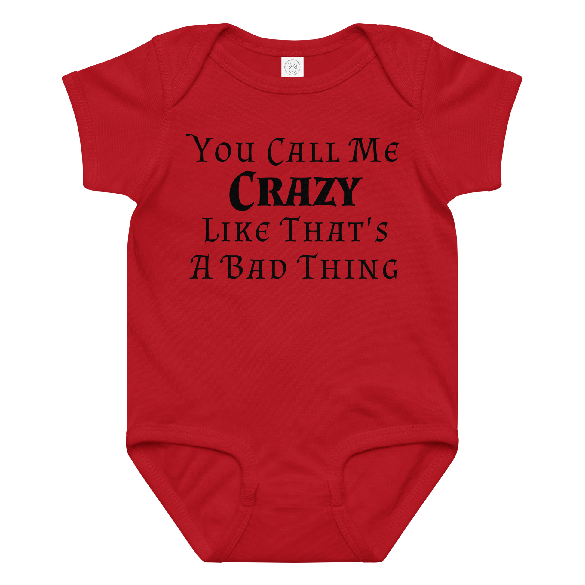 "You Call Me Crazy Like That's A Bad Thing" printed on a red baby jersey bodysuit laying on a flat surface amongst other clothes