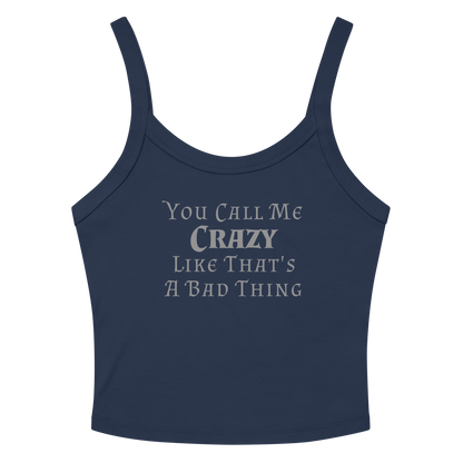 "You Call Me Crazy Like That's A Bad Thing" printed on a solid navy blend women's micro-rib tanktop laying on a flat surface amongst sunglasses and shorts