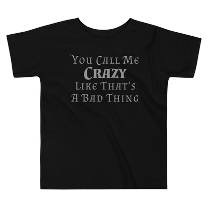 "You Call Me Crazy Like That's A Bad Thing" printed on a black toddler short sleeve tee laying on a flat surface