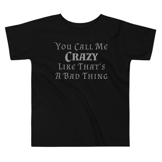 "You Call Me Crazy Like That's A Bad Thing" printed on a black toddler short sleeve tee laying on a flat surface
