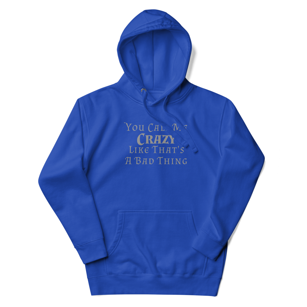 "You Call Me Crazy Like That's A Bad Thing" printed on a team royal unisex hoodie laying on a flat surface with the hood up
