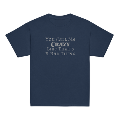 "You Call Me Crazy Like That's A Bad Thing" printed on a navy youth classic tee laying on a flat surface