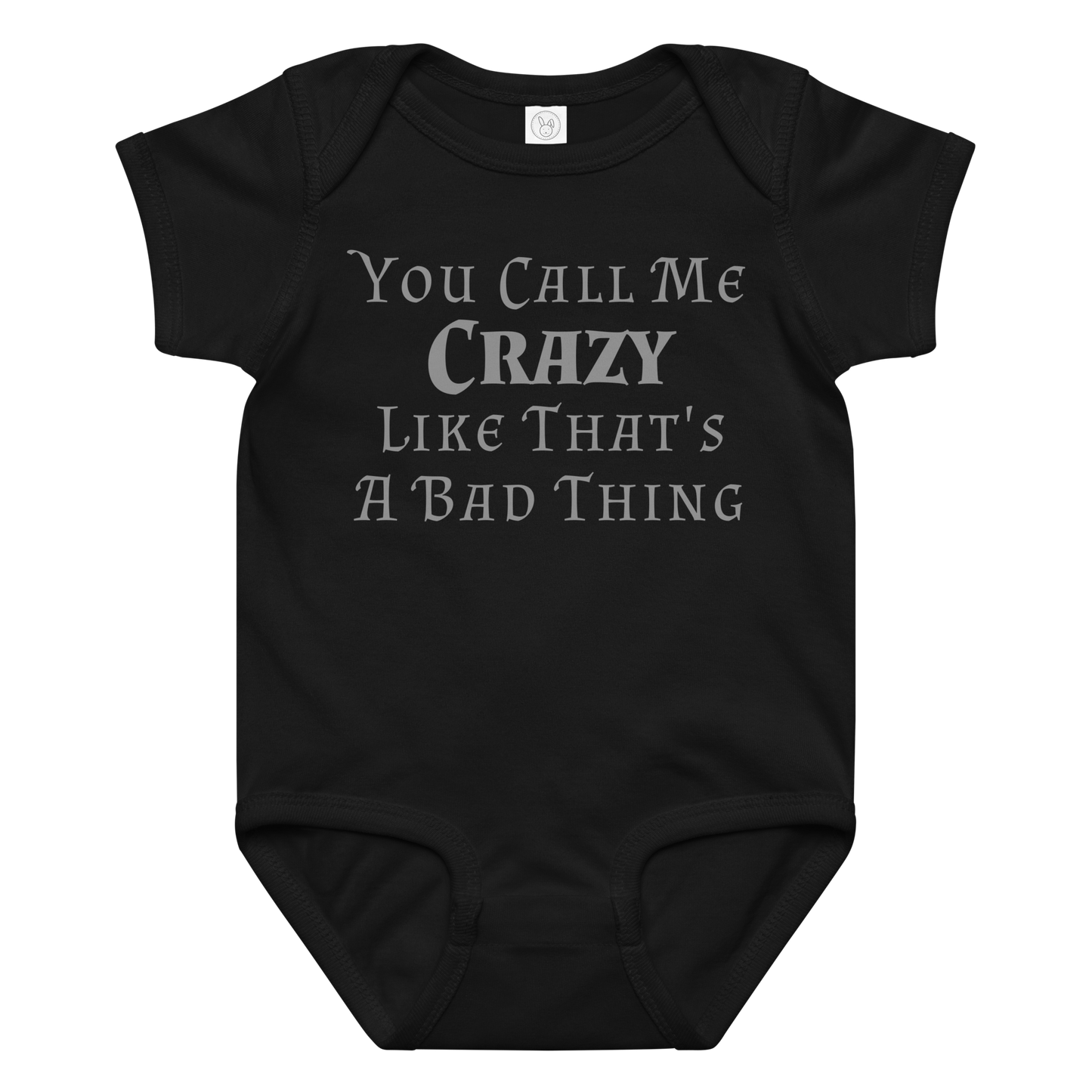"You Call Me Crazy Like That's A Bad Thing" printed on a black baby jersey bodysuit laying on a flat surface amongst other clothes