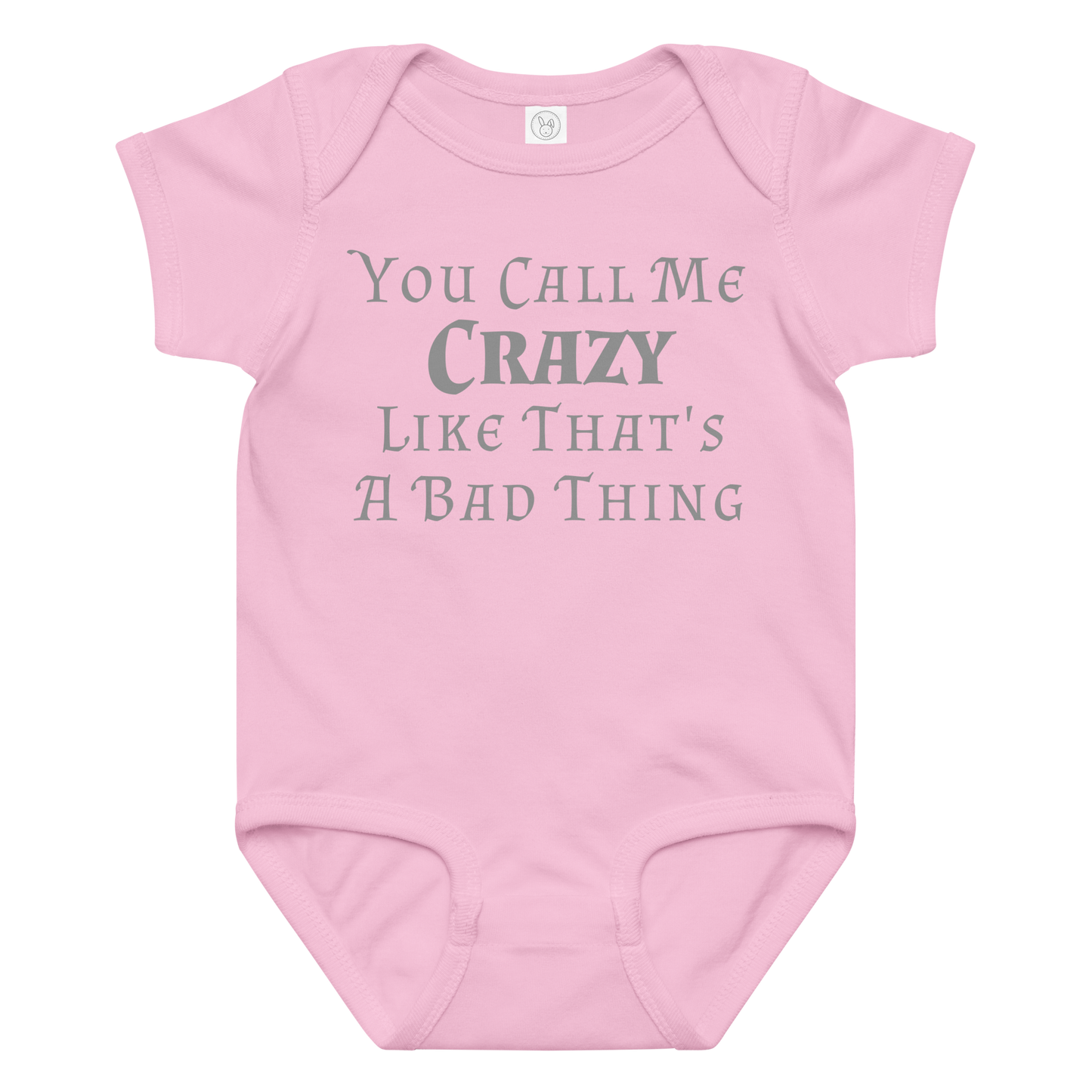 "You Call Me Crazy Like That's A Bad Thing" printed on a pink baby jersey bodysuit laying on a flat surface amongst other clothes